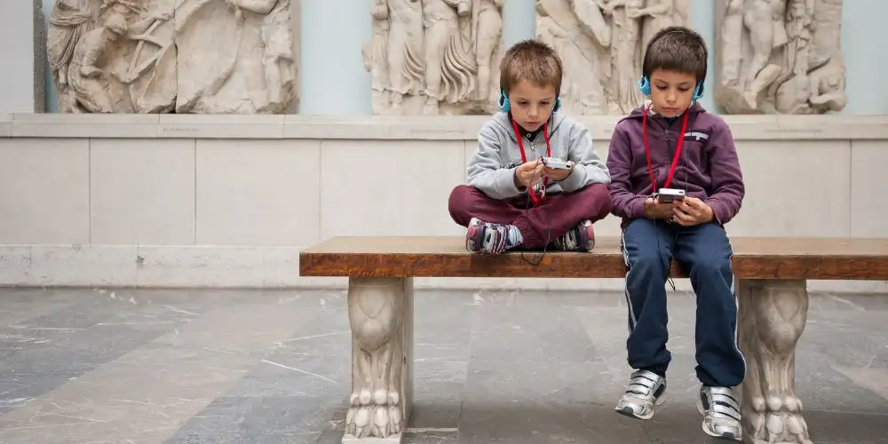 Kinder lauschen dem Audioguide im Pergamonmuseum in Berlin