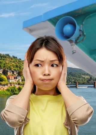 Meisje ergert zich aan audiogids met luidspreker op rivierboottocht